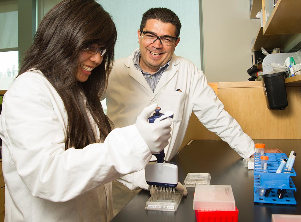 Luís Carvajal-Carmona talks with Anna Marie Tuazon, a graduate student in Biochemistry, Molecular, Cellular, and Developmental Biology